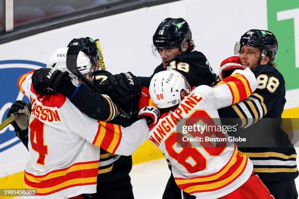 Boston, MA From left, Boston Bruins LW Jake DeBrusk, C Pavel Zacha, and RW David Pastrnak fight Calgary Flames D Rasmus Andersson and LW Andrew...