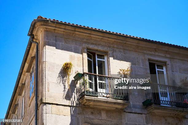 low angle view of the exterior of a house with balcony railings and closed window, sky in the background - vigo stock pictures, royalty-free photos & images