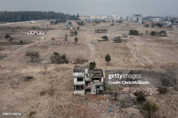 An aerial view of a damaged apartment block amid cleared land where residential buildings once stood before last years earthquake on February 04,...