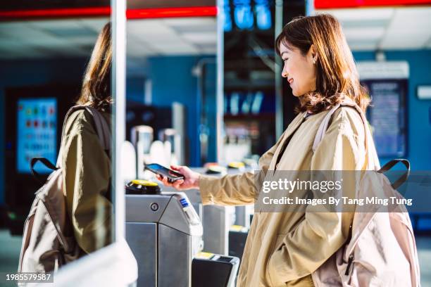beautiful businesswoman doing contactless payment with smart phone at ticket gate in train station - passenger train stock pictures, royalty-free photos & images