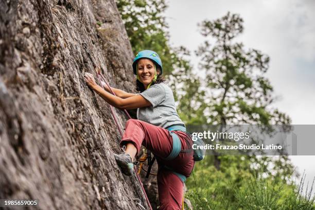 porträt einer bergsteigerin beim bergsteigen - klettern stock-fotos und bilder