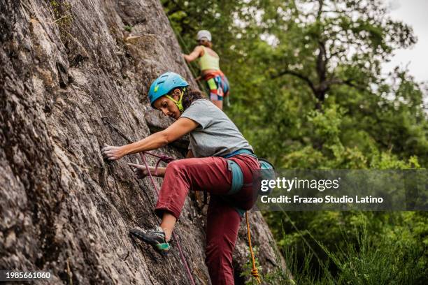 escaladora femenina escalando montaña - escalada en roca fotografías e imágenes de stock