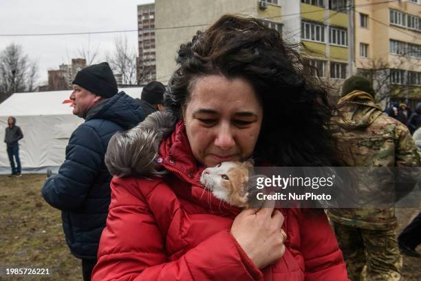 Local woman with a cat is reacting next to a burning residential high-rise building damaged by a massive Russian missile strike in Kyiv, Ukraine, on...