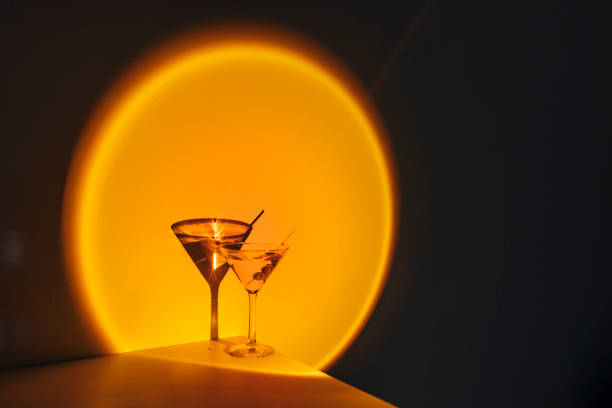 creative image of martini cocktail glass on orange neon light in nightclub bar - orange cocktail stock pictures, royalty-free photos & images