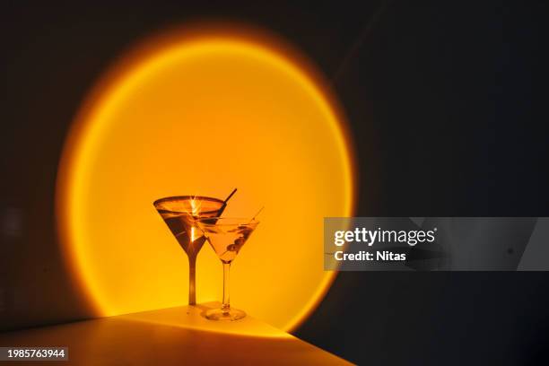 creative image of martini cocktail glass on orange neon light in nightclub bar - vintage crockery stock pictures, royalty-free photos & images