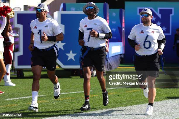 Jalen Hurts of the Philadelphia Eagles, Geno Smith of the Seattle Seahawks, and Baker Mayfield of the Tampa Bay Buccaneers and NFC run onto the field...