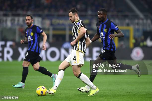 Federico Gatti of Juventus passes the ball whilst under pressure from Marcus Thuram of FC Internazionale during the Serie A TIM match between FC...