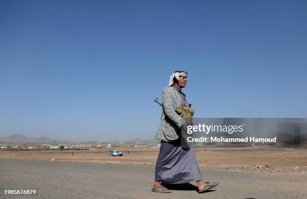 Houthi fighter walks to attend a rally in support of Palestinians in the Gaza Strip, and the recent Houthi strikes on shipping in the Red Sea and...