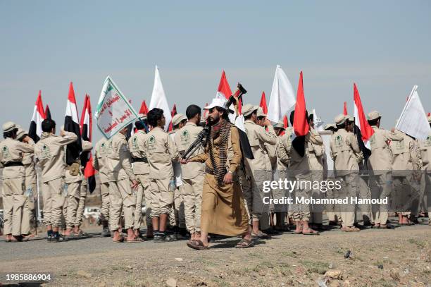 Scout team members carry Yemeni and Palestinian flags and placards depicting Yemen's Houthi leader Abdul Malek Bader AL-Den Al-Houthi and Houthi...