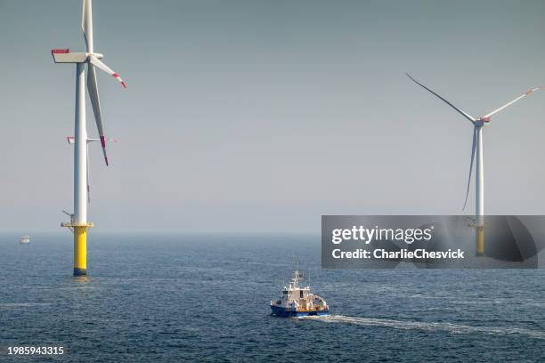 lever de soleil épique sur le parc éolien offshore et la sous-station à l’horizon, navire entre eux, ciel lumineux, borkum riffgrund allemagne - mer du nord photos et images de collection