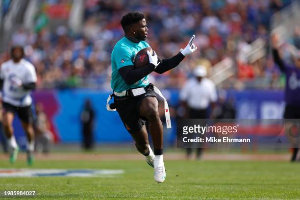 Tyreek Hill of the Miami Dolphins and AFC reacts as he runs the ball for a touchdown during the first quarter of the 2024 NFL Pro Bowl Games at...