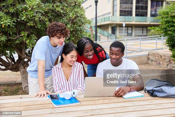multiethnic group of teenage students studying with laptop computer on the school campus - laptop netbook stock pictures, royalty-free photos & images