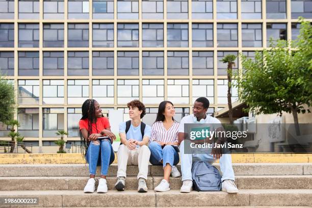 multiethnic group of smiling young students talking together outside college on campus - laptop netbook stock pictures, royalty-free photos & images