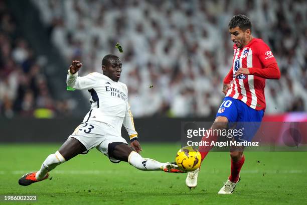 Angel Correa of Atletico Madrid is tackled by Ferland Mendy of Real Madrid during the LaLiga EA Sports match between Real Madrid CF and Atletico...