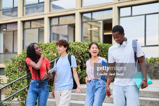 cheerful multiethnic students walking down the stairs on the college campus - laptop netbook stock pictures, royalty-free photos & images