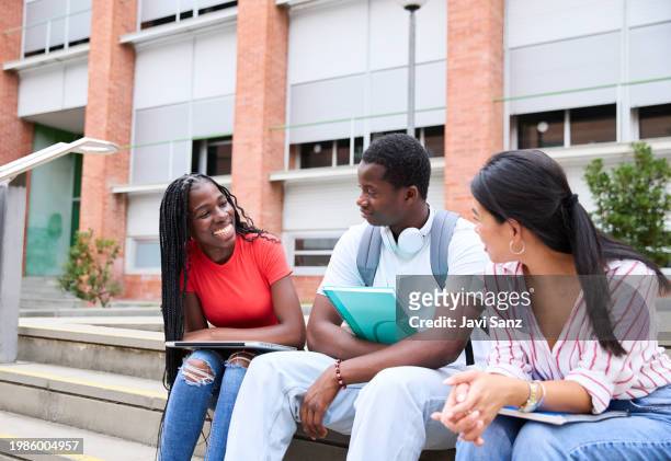 group of teenage multiethnic students talking and laughing together outside the college - laptop netbook stock pictures, royalty-free photos & images
