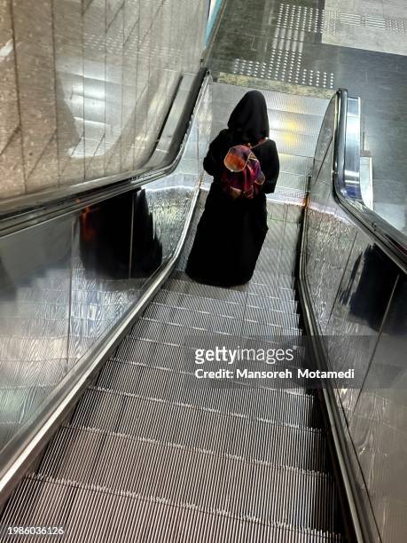 muslim woman on the subway escalator - iran coronavirus stock pictures, royalty-free photos & images