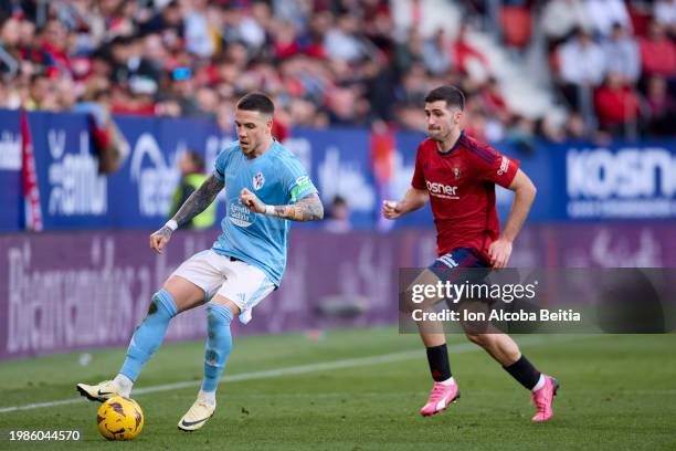 Mihailo Ristic of RC Celta compete for the ball with Jesus Areso of CA Osasuna during the LaLiga EA Sports match between CA Osasuna and Celta Vigo at...