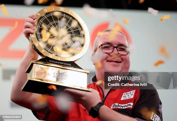 Stephen Bunting celebrates with the trophy after beating Michael van Gerwen and winning 2024 PDC Cazoo Masters Darts Final at Marshall Arena on...