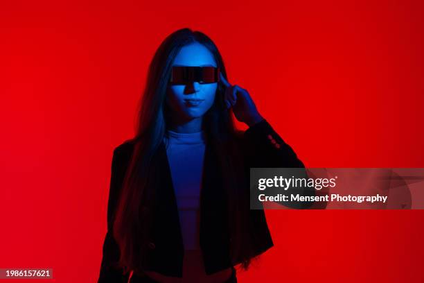 futuristic modern woman with smart glasses and red glowing background - gel effect lighting 個照片及圖片檔