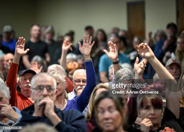 Attendees raise their response in regards to issues related to the immigrant population in the Denver Metro area during an emergency citizens'...