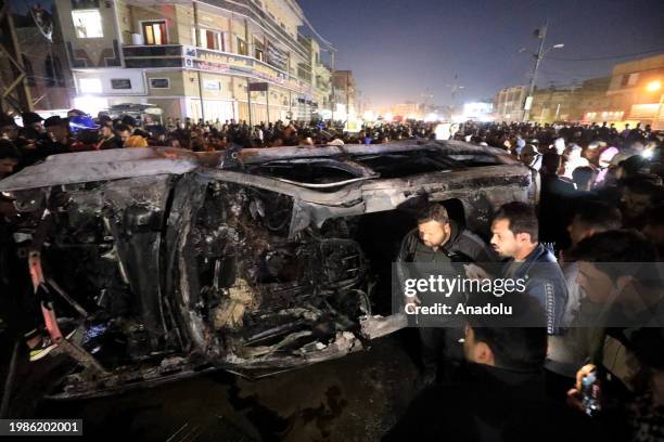 People inspect the vehicle targeted by airstrike in Baghdad, Iraq on February 07, 2024. At least 3 explosions heard across Iraqi capital Baghdad,...