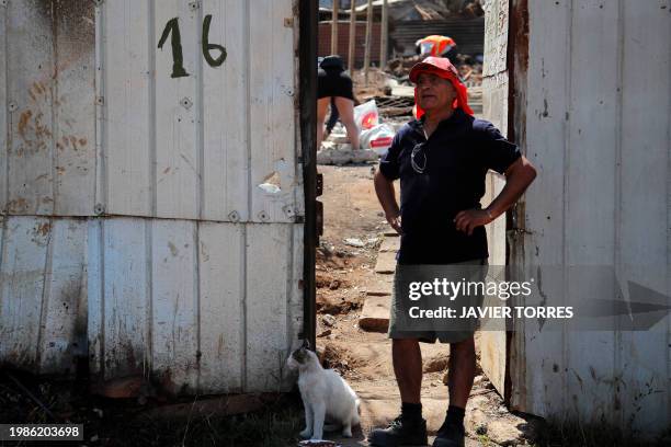 Residents remove debris from burned houses after a forest fire in the Poblacion Monte Sinai neighborhood in Viña Del Mar, Chile, on February 7, 2024....