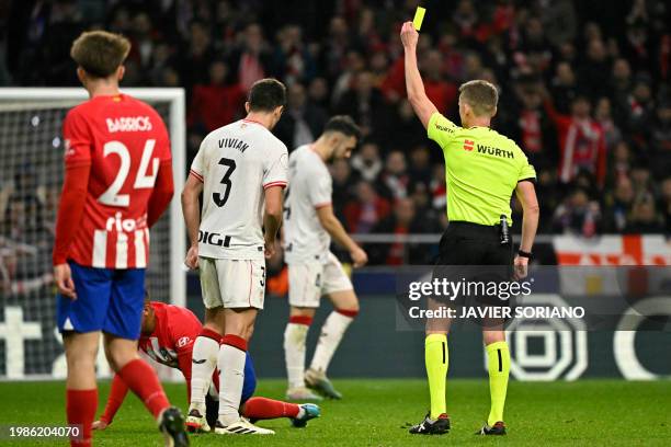 Spanish referee Alejandro Hernandez Hernandez presents a yellow card to Athletic Bilbao's Spanish defender Dani Vivian during the Spanish Copa del...