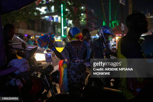 Street vendor waves small national flags of the Democratic Republic of Congo as DR Congo's Leopards supporters watch the Africa Cup of Nations 2024...