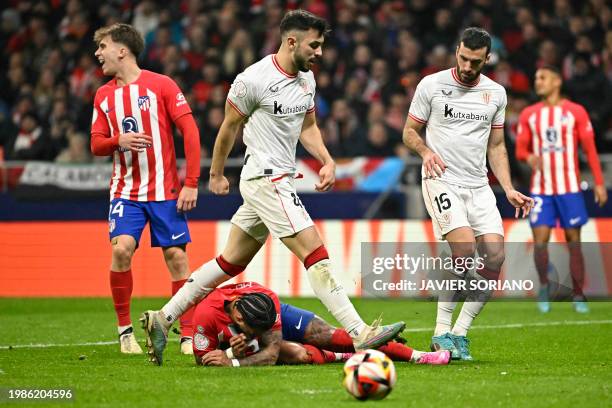 Athletic Bilbao's Spanish midfielder Benat Prados walks over Atletico Madrid's Dutch forward Memphis Depay during the Spanish Copa del Rey semi final...