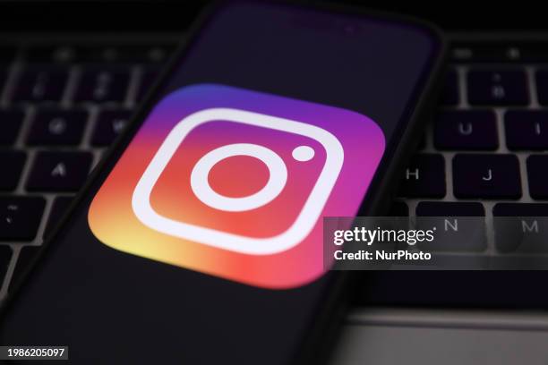 Laptop keyboard and Instagram logo displayed on a phone screen are seen in this illustration photo taken in Krakow, Poland on February 7, 2024.