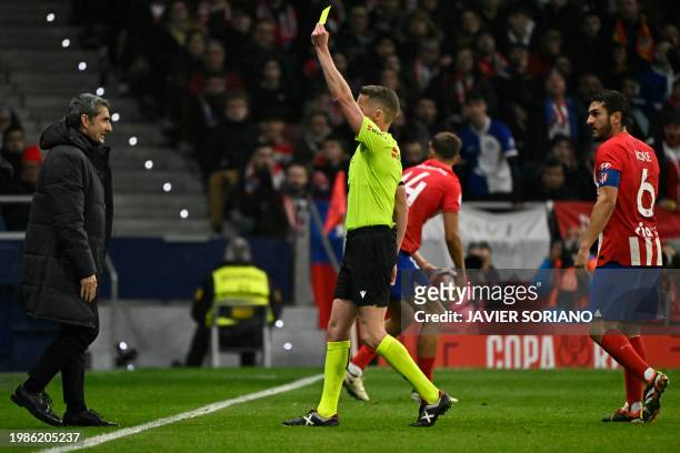 Spanish referee Alejandro Hernandez Hernandez presents a yellow card to Athletic Bilbao's Spanish coach Ernesto Valverde during the Spanish Copa del...