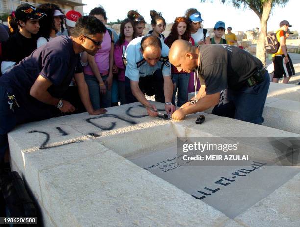 Israeli police clean up neo-Nazi graffiti sprayed on the grave of Israel's founding father and first prime minister, David Ben Gurion, in the...