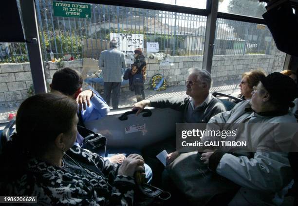 Israeli commuters look 25 February 2004 at the site where a Palestinian suicide bomber blew himself up 22 February 2004 in Jerusalem, killing eight...