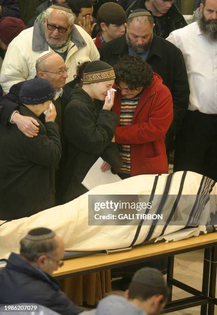 Hagit Arbel mourns next to the body of her husband Royi Arbel during his funeral at the synagogue of the West Bank settlement of Talmon 14 January...