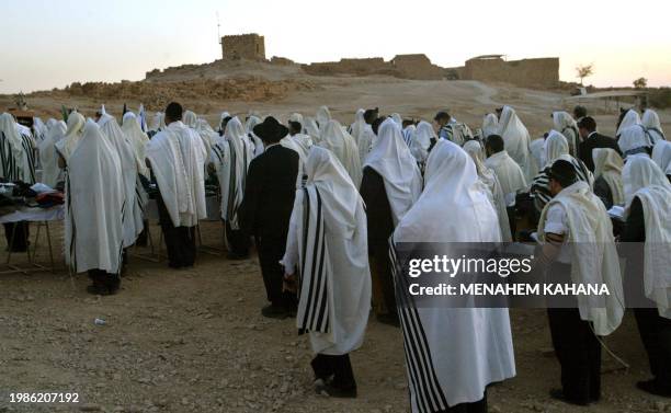 Ultra-Orthodox Jews wearing prayer shawls are seen during the Morning prayer at sunrise on top of the ancient desert fortress of Masada in southern...