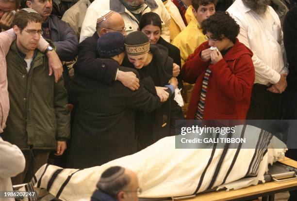 Hagit Arbel mourns next to the body of her husband Royi Arbel during his funeral at the synagogue of the West Bank settlement of Talmon 14 January...