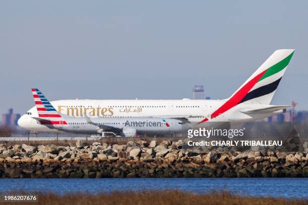 Boeing 733 passenger aircraft of American airlines to Austin and an Airbus A380 passenger aircraft of Emirates airlines to Dubai prepare to take off...