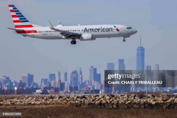 Boeing 737 passenger aircraft of American Airlines arrives from Austin at JFK International Airport in New York as the Manhattan skyline looms in the...