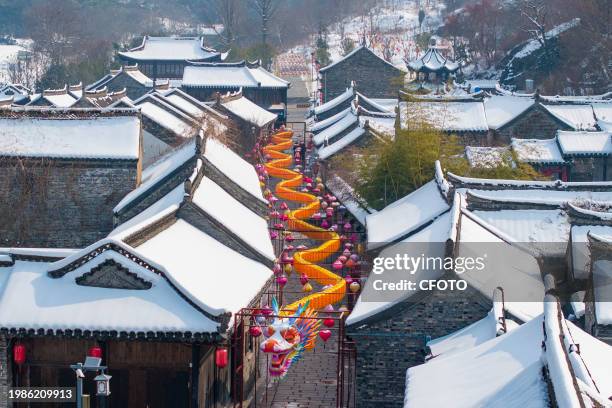 Giant dragon lantern stands out against the snowy scenery and ancient buildings on Huangpai Street in Xuyi County of Huai 'an city, East China's...