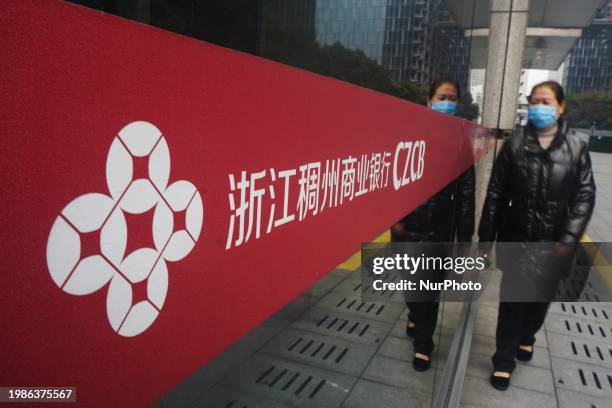 Citizen is walking past the headquarters of Chouzhou Commercial Bank in Hangzhou, East China's Zhejiang province, on February 8, 2024.