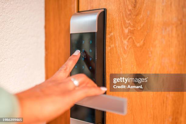 mature hispanic female using a digital security keypad at home - keycard access stock pictures, royalty-free photos & images