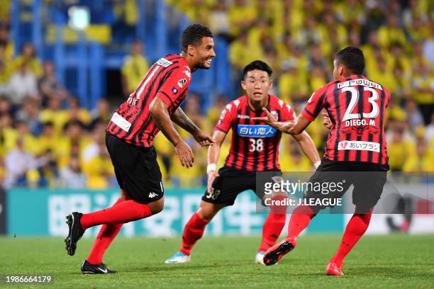 Jonathan Reis of Consadole Sapporo celebrates with teammate Diego Macedo and Daiki Suga after scoring the team's first goal during the J.League J1...