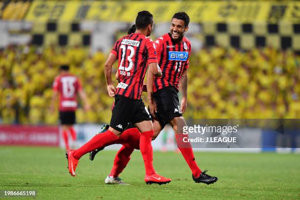 Jonathan Reis of Consadole Sapporo celebrates with teammate Diego Macedo and Daiki Suga after scoring the team's first goal during the J.League J1...