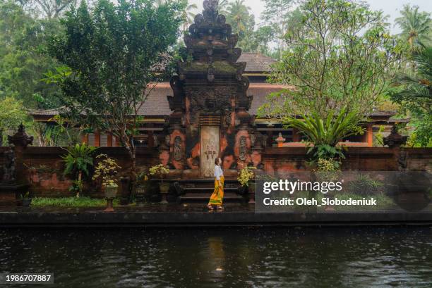 mujer caminando cerca de la pagoda en el templo de tirta empul - bali fotografías e imágenes de stock