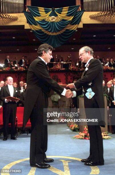 American Robert C. Merton receives the Nobel Prize in Economics from Swedish King Carl XVI Gustaf at the Concert Hall in Stockholm, Sweden, late 10...