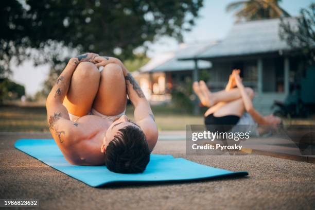 friends practicing yoga by the pool - foetushouding stockfoto's en -beelden