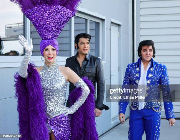 Showgirl and Elvis Presley impersonators walk outside a hangar at Harry Reid International Airport before the Kansas City Chiefs and the San...