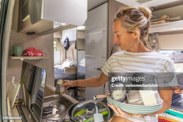 doing the dishes inside a camper van - messy car interior stock pictures, royalty-free photos & images