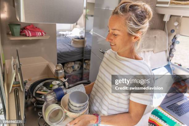 doing the dishes inside a camper van - messy car interior stock pictures, royalty-free photos & images